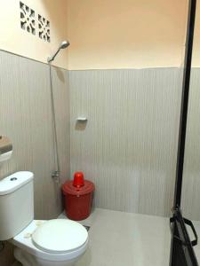 ein Badezimmer mit einem WC und einem roten Mülleimer in der Unterkunft Eve's Place Transient Apartment in Tanay