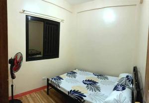 Schlafzimmer mit einem Bett, einem Spiegel und einem Fenster in der Unterkunft Eve's Place Transient Apartment in Tanay