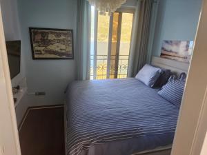 a small bedroom with a bed with a window at Apartment Galina in Tivat