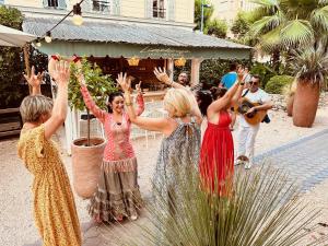 um grupo de mulheres em pé na frente de um grupo de pessoas em Hôtel De Londres em Menton