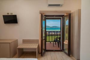 a bedroom with a balcony with a view of the ocean at Hotel Portoconte in Porto Conte