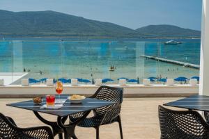 a table and chairs with a view of the ocean at Hotel Portoconte in Porto Conte