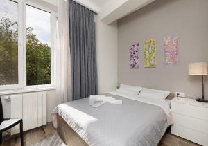 a bedroom with a bed and a large window at HD New Apartment in Tbilisi City