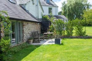 a stone cottage with a table and chairs in the yard at The Tractor Shed in Usk