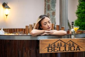 a woman sitting in a bar with a sign at Beluga Guest House in Velingrad