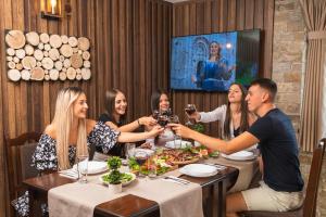 a group of people sitting around a table in a restaurant at Beluga Guest House in Velingrad