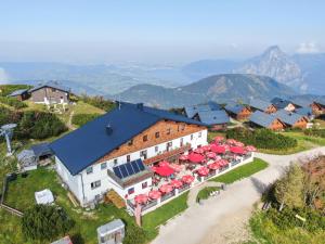 eine Luftansicht eines Gebäudes mit roten Sonnenschirmen in der Unterkunft Berggasthof Edelweiss in Ebensee