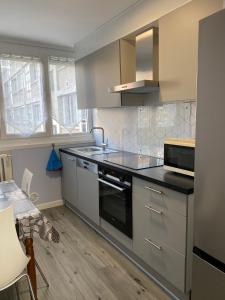 A kitchen or kitchenette at Le Cosy, Appartement Chaleureux 2 chambres