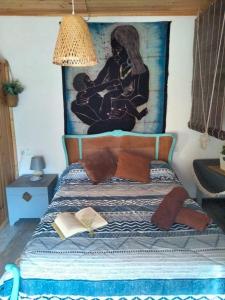 1 dormitorio con 1 cama con una pintura en la pared en Casa rural La Libelula Ayna, en Ayna