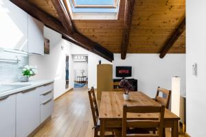 eine Küche und ein Esszimmer mit einem Holztisch und Stühlen in der Unterkunft Liberty House - Vicina fermate Bus e Treno per Torino in Chieri
