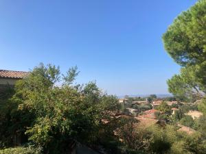 Blick auf eine Stadt mit Bäumen im Vordergrund in der Unterkunft La Biocca in Poggio Murella