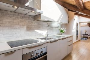 eine Küche mit weißen Schränken und einer Spüle in der Unterkunft Liberty House - Vicina fermate Bus e Treno per Torino in Chieri