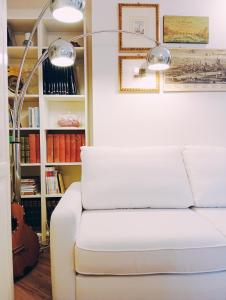 un sofá blanco en una sala de estar con lámpara en Viaemilia Alessandria, en Alessandria