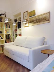 un sofá blanco en una sala de estar con mesa en Viaemilia Alessandria, en Alessandria
