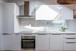 eine Küche mit weißen Schränken und einer Spüle in der Unterkunft Liberty House - Vicina fermate Bus e Treno per Torino in Chieri