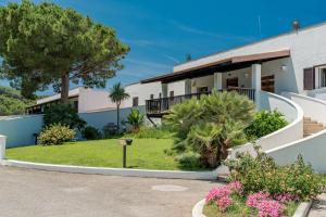 a house with a garden in front of it at Hotel Portoconte in Porto Conte