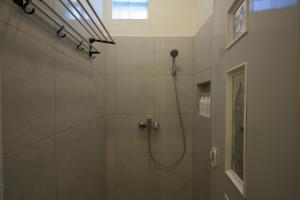 W łazience znajduje się prysznic z głowicą prysznicową. w obiekcie Aiwan Hostel & Luggage storage w mieście Sanur