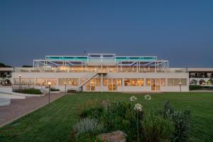 a large building with a lawn in front of it at Hotel Portoconte in Porto Conte