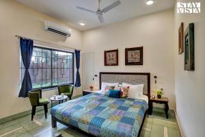 1 dormitorio con cama, escritorio y ventana en StayVista's Madan Villa - City-Center Villa with Manicured Lawn & Picturesque Sit-Outs, en Jodhpur