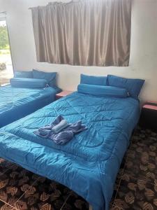 una camera con due letti con lenzuola blu di นามนโฮมสเตย์ (บ้านพ่อเสถียร) 