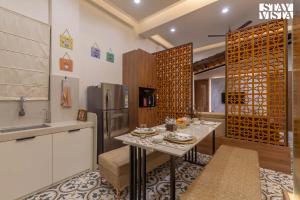 una cocina con una mesa y un refrigerador en StayVista's Coral Breeze with Plunge Pool, Games Room, Projector Setup, Proximity to Secluded Beach, en Dapoli