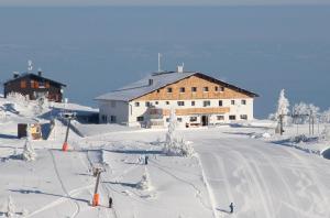 eine Skilodge auf einer schneebedeckten Piste mit einem Skilift in der Unterkunft Berggasthof Edelweiss in Ebensee