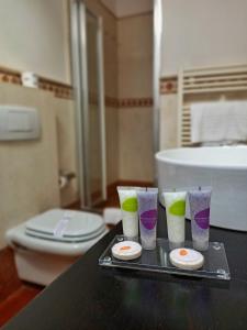 a tray with four cups and a toilet in a bathroom at Aquazzurra Resort & Aparthotel in Cannobio