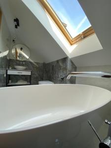 a white bath tub in a bathroom with a skylight at Stara Plebania in Ponice +58 photos