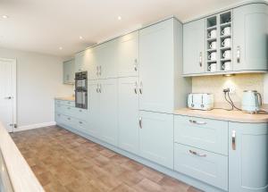 a kitchen with white cabinets and a tile floor at Spa Home with Pool Sauna Hot Tub Cocktail Bar in Sheffield