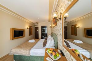 a hotel room with two beds and a table with fruit on a tray at Grand Hamit Hotel in Ankara