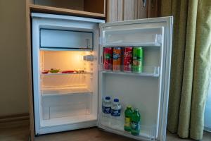 an open refrigerator filled with drinks and soda at Grand Hamit Hotel in Ankara