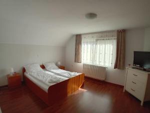 a small bedroom with a bed and a television at Casa Larisa in Vişeu de Sus