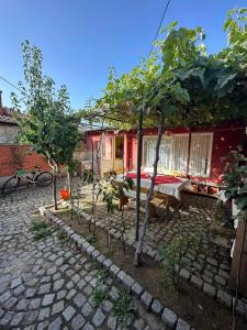 a house with a table and trees in front of it at Tainov House in Samokov