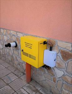 una caja amarilla en el costado de una pared en Tainov House, en Samokov