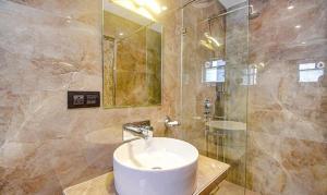 La salle de bains est pourvue d'un lavabo et d'une douche. dans l'établissement FabHotel Jalsa Residency New Town, à Kolkata