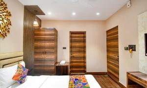 a bedroom with a bed and a wooden door at FabHotel Jalsa Residency New Town in Kolkata