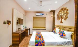 a bedroom with a bed with a desk and a sink at FabHotel Jalsa Residency New Town in Kolkata