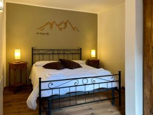 a bed in a bedroom with two night stands and two lamps at La Corte della Casera in Cassina Valsassina