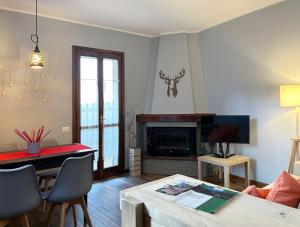 a living room with a table and a fireplace at La Corte della Casera in Cassina Valsassina