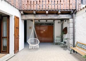 a porch with a swing in front of a building at La Corte della Casera in Cassina Valsassina