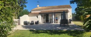 a small white building with chairs in a yard at L'Ecrin des Alpilles in Graveson