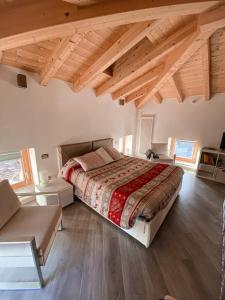 a bedroom with a large bed in a room with wooden ceilings at La Casa sulla collina del Castello in Breno