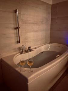 two glasses of wine sitting on a bath tub at La Casa sulla collina del Castello in Breno