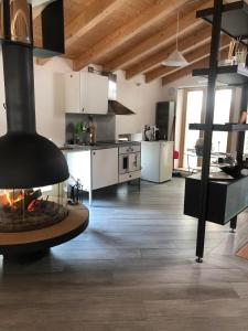 a kitchen with a fireplace in the middle of a room at La Casa sulla collina del Castello in Breno