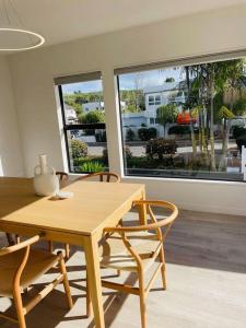 a dining room with a wooden table and chairs at Spacious Mission Bay Villa 100m to the beach, seaview, private garden, Netflix in Auckland