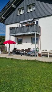 a house with a balcony and a table and chairs at Kleine Auszeit in Lauben