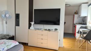 a living room with a flat screen tv on a white cabinet at Kleine Auszeit in Lauben