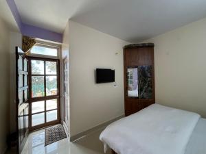 a bedroom with a bed and a window at Zu-Zu Hostels in Shimla