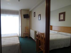 a hotel room with two beds and a mirror at Hotel Akelarre in Santiago de Compostela
