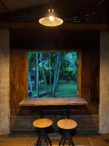 a window with two stools in front of it at Cabinthai in Mae Chaem